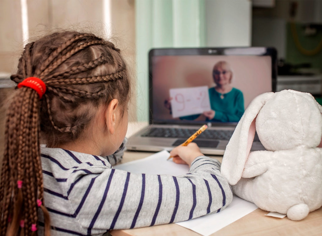 little girl watching lesson on laptop