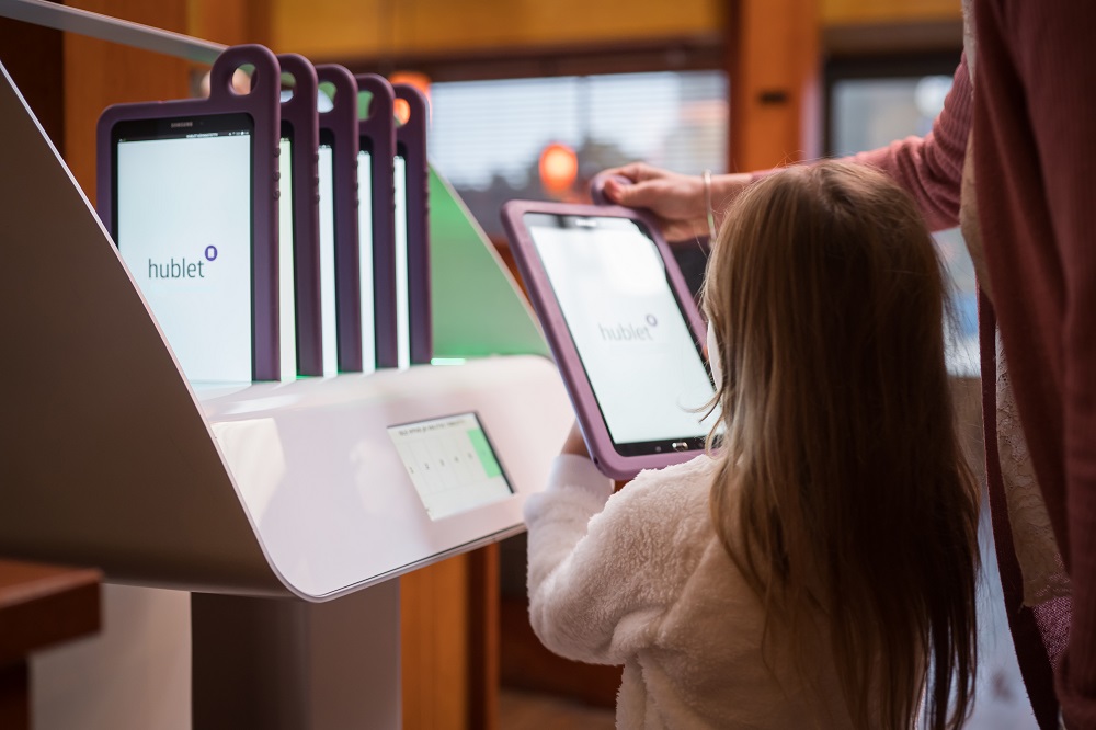 Mother takes Hublet tablet from Docking Station for daughter