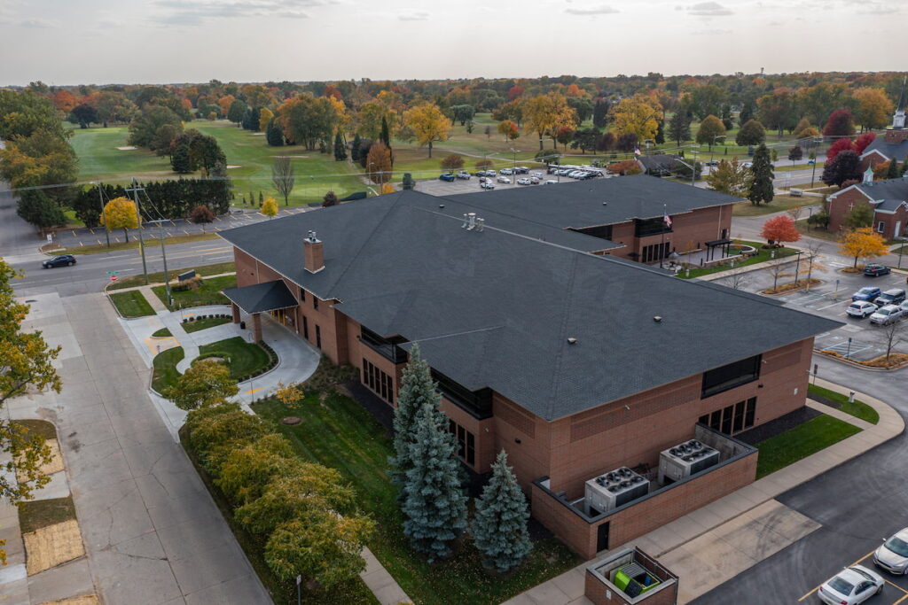 Aerial view of Redford Township District Library entrance with U.S. flag and outdoor seating area.