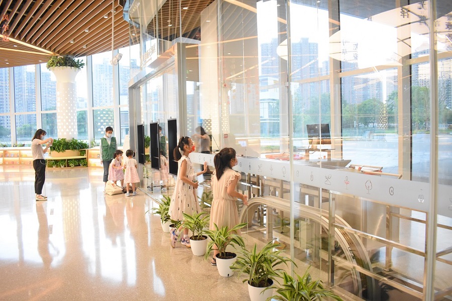 Children observing an automated book return system at the Shanghai Public Library