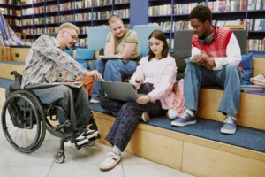 Three diverse students collaborating in a modern library, highlighting accessibility and inclusion.