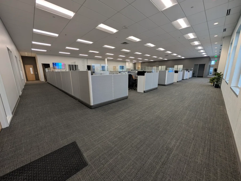 A wide view of Bibliotheca’s open office space with rows of modern, gray cubicles under bright, even lighting.