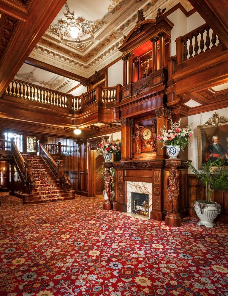 Ornate wooden interior of the Turnblad Mansion, home of the American Swedish Institute, showcasing its carved staircase and elaborate design.